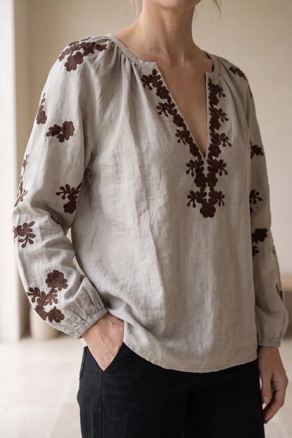 Blusa de lino gris con bordados florales marrones y escote en V