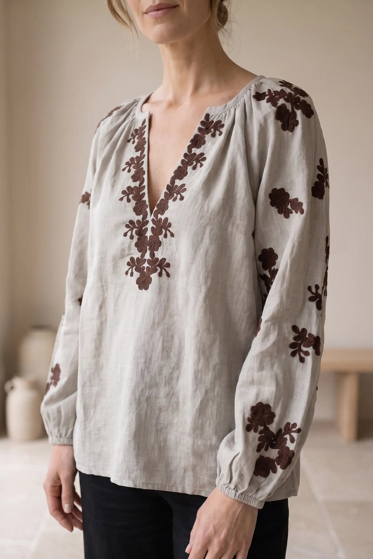 Blusa de lino beige con bordados florales marrones y cuello en V