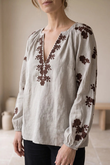Blusa de lino beige con bordados florales marrones y cuello en V