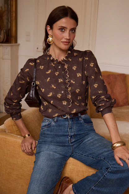 Blusa floral marrón con volantes y jeans azules, estilo femenino y elegante