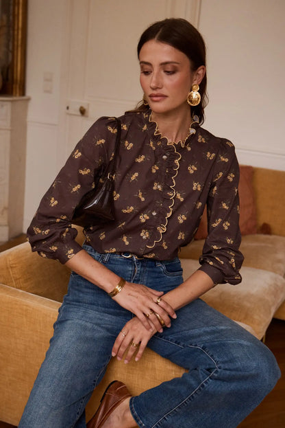 Camisa floral marrón con volantes y jeans azules, look femenino y elegante para mujer
