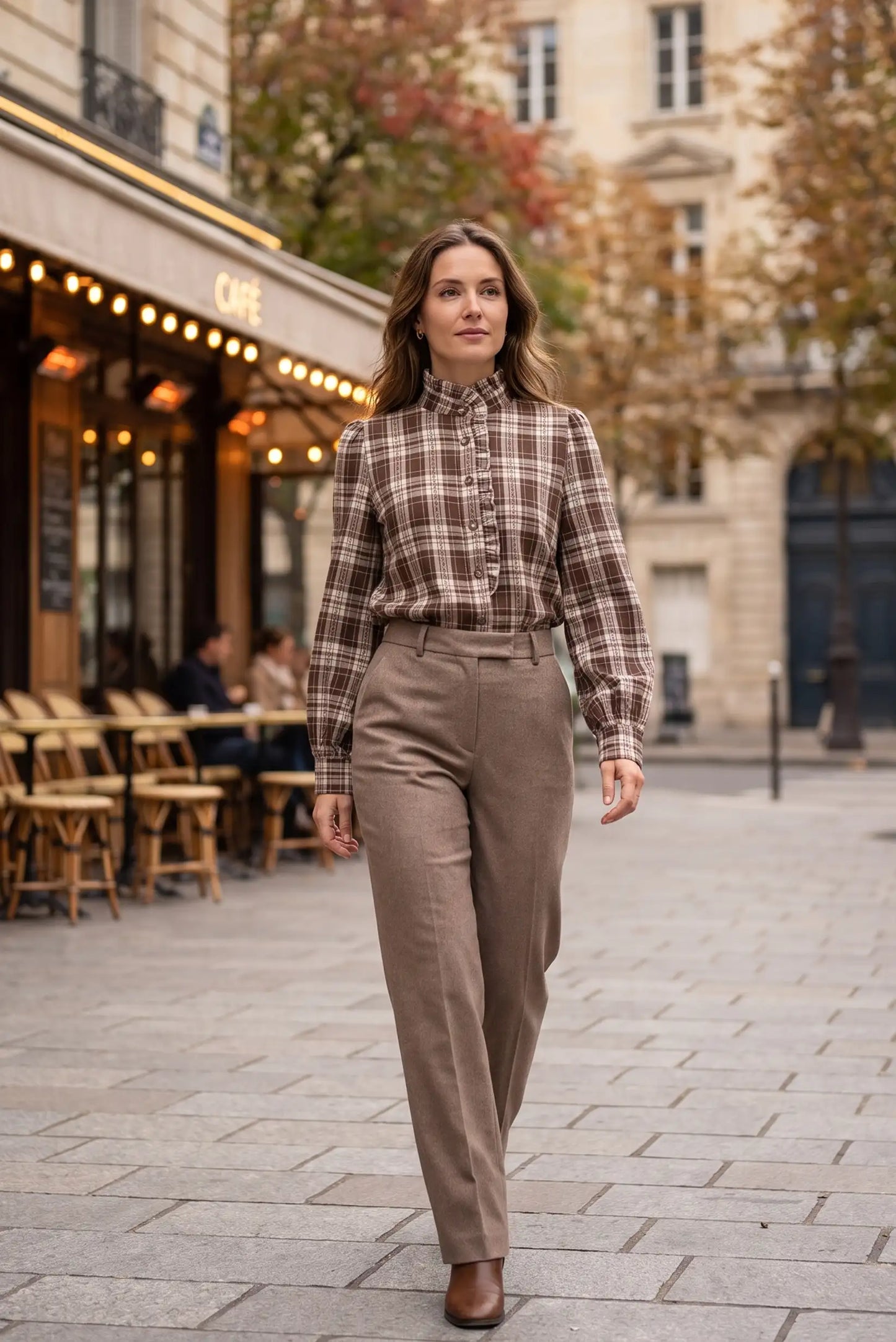Mujer con camisa a cuadros marrón y pantalones beige en calle urbana, moda femenina elegante