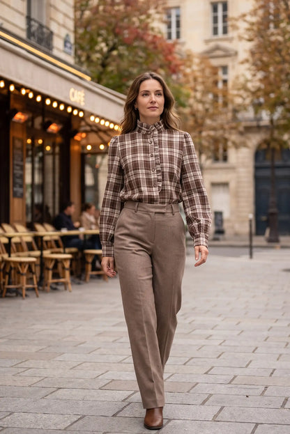 Mujer con camisa a cuadros marrón y pantalones beige en calle urbana, moda femenina elegante