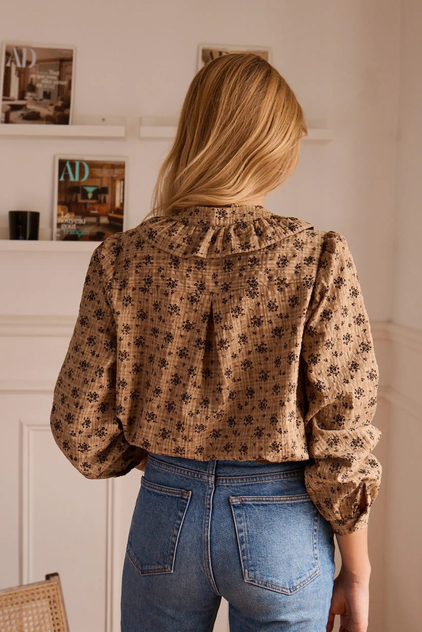Blusa con estampado floral y mangas voluminosas, combinada con jeans azules