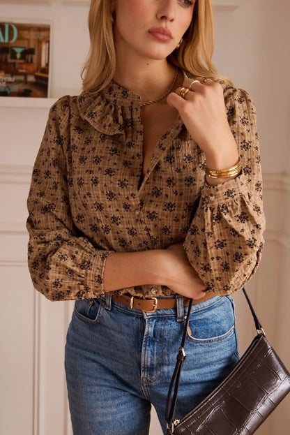 Blusa estampada con flores y cuello fruncido, combinada con jeans y bolso de cuero