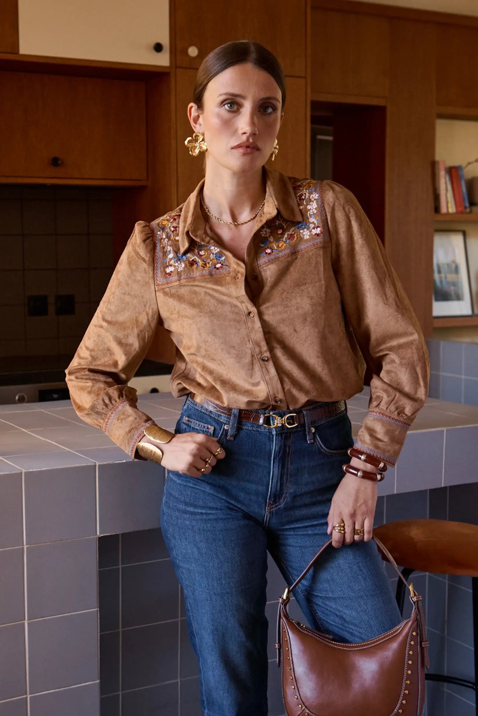 Camisa marrón bordada con jeans y bolso de cuero, moda femenina elegante