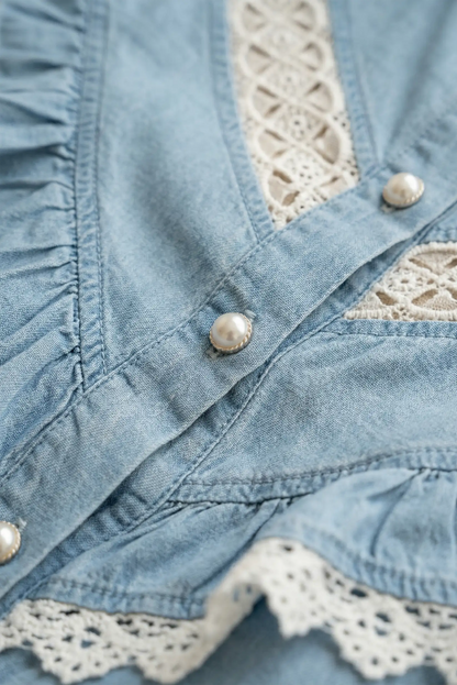 Detalle de camisa vaquera azul de mujer con encaje blanco y botones tipo perla