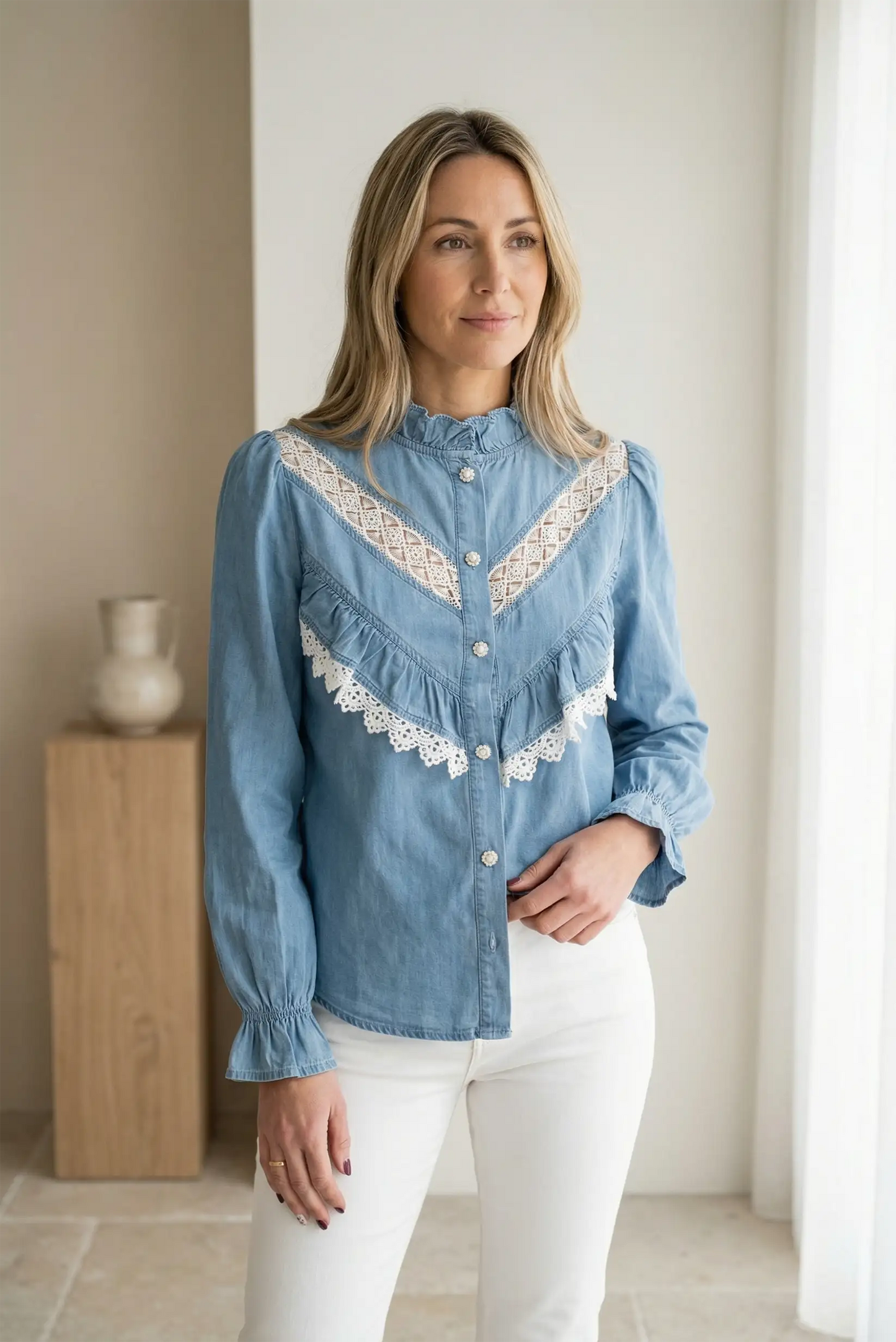 Camisa vaquera azul de mujer con manga larga y detalles de puntilla blanca, look casual elegante.