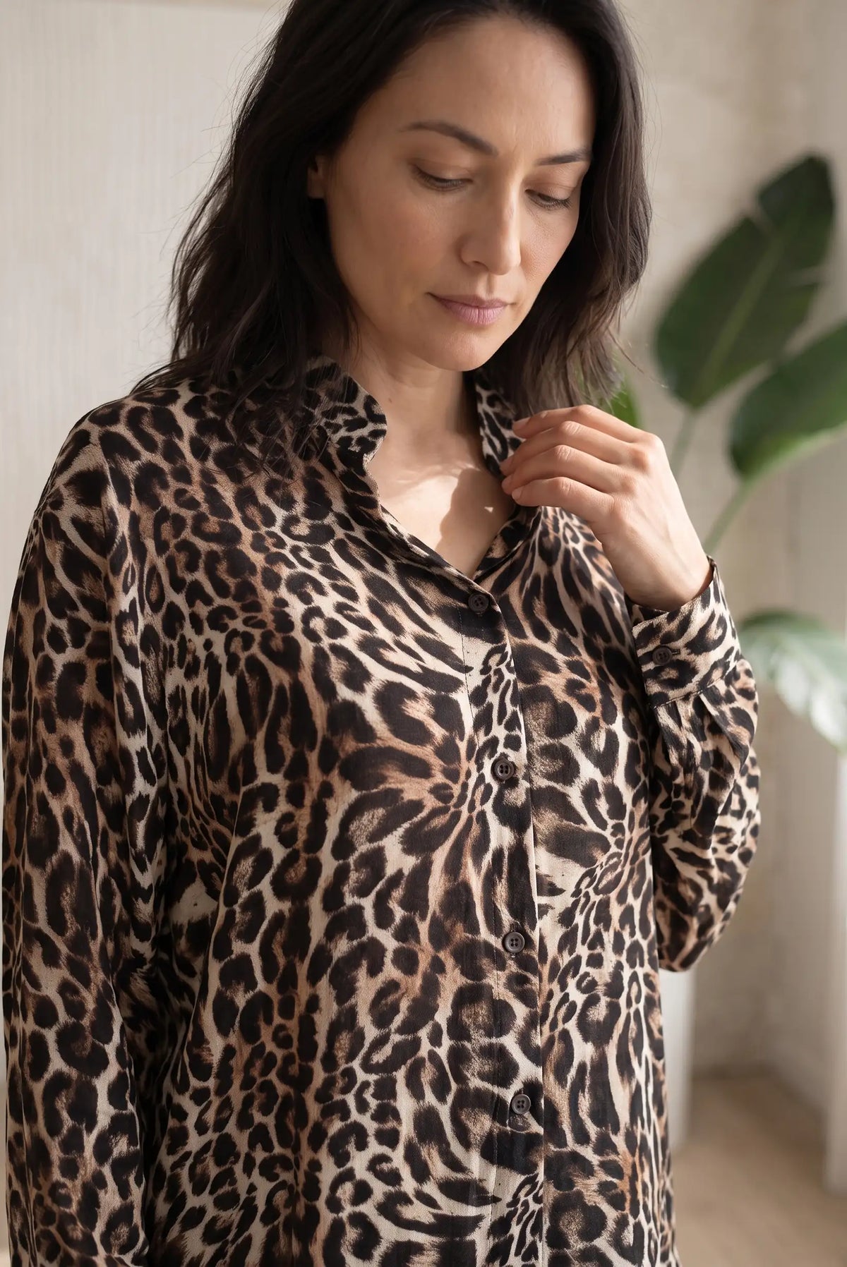 Mujer vistiendo camisa de CHICA del Sur con estampado de leopardo en tonos marrón y beige.