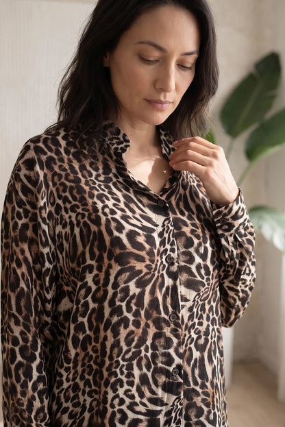 Mujer vistiendo camisa de CHICA del Sur con estampado de leopardo en tonos marrón y beige.
