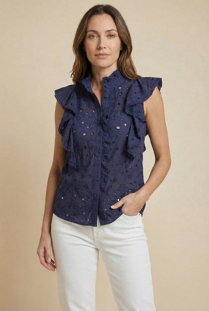 Mujer con blusa azul marino sin mangas, volantes y detalles calados, look casual primavera.