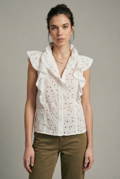 Mujer con blusa blanca calada de primavera sin mangas y volantes, moda femenina casual.