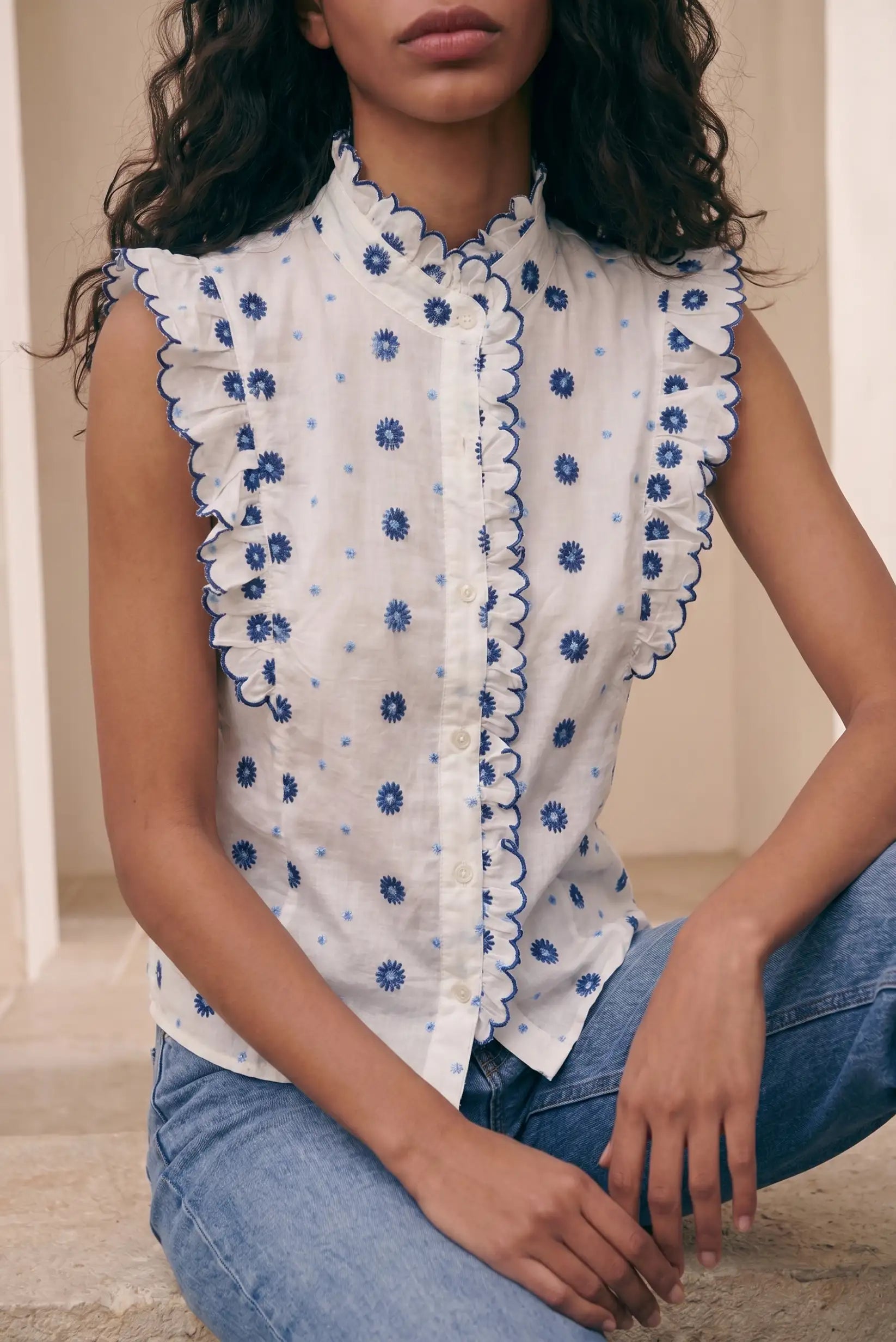 Camisa sin mangas blanca para mujer con bordados florales azules y volantes, look casual
