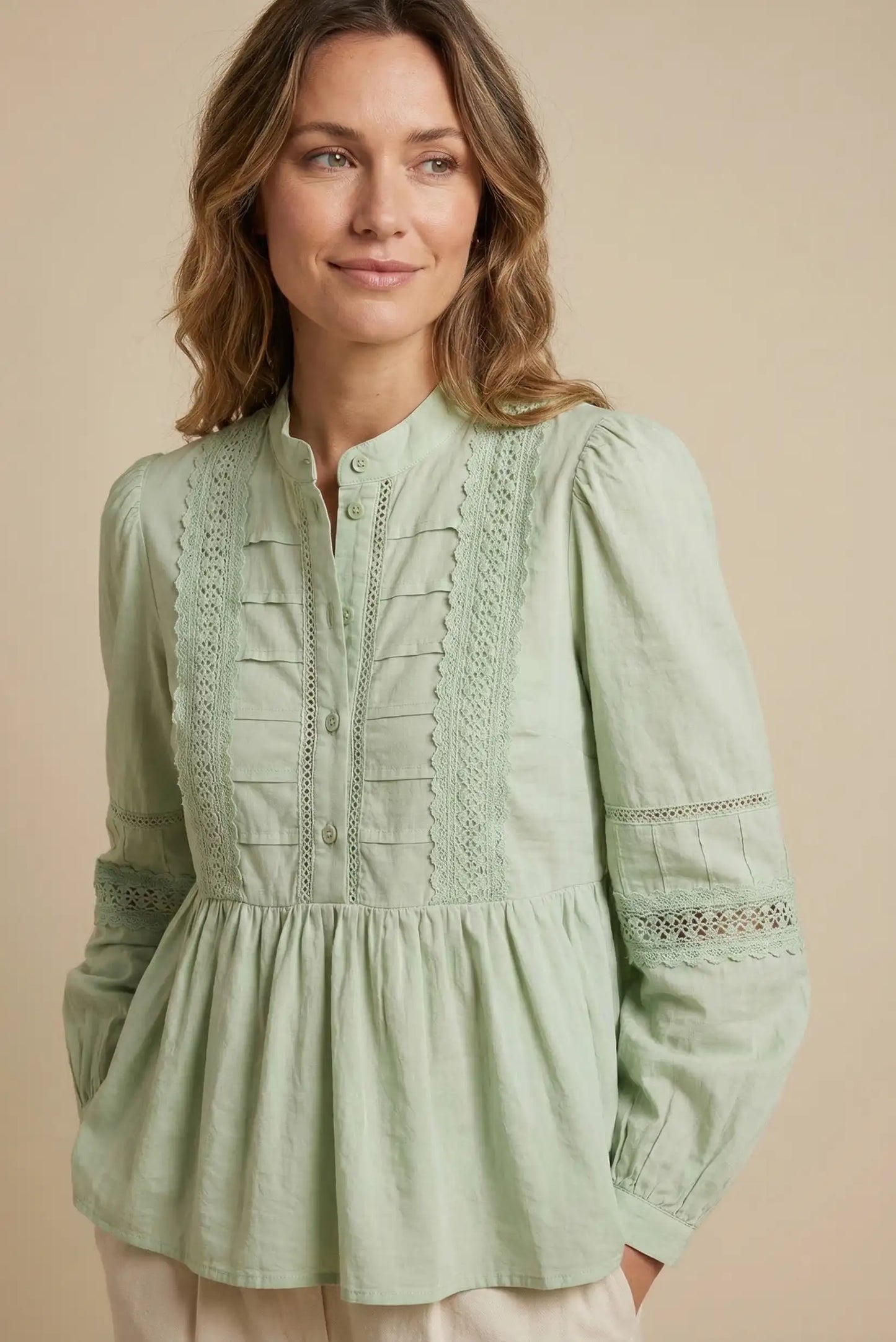Mujer con blusa verde agua de manga larga y encaje, estilo casual primavera