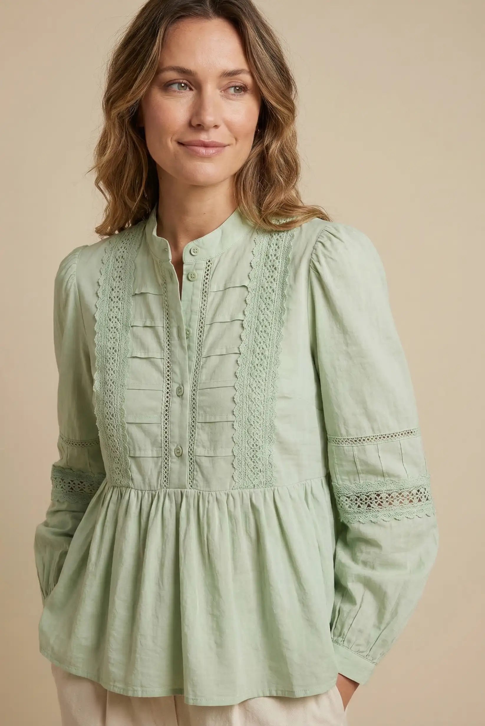Mujer con blusa verde agua de manga larga y encaje, estilo casual primavera