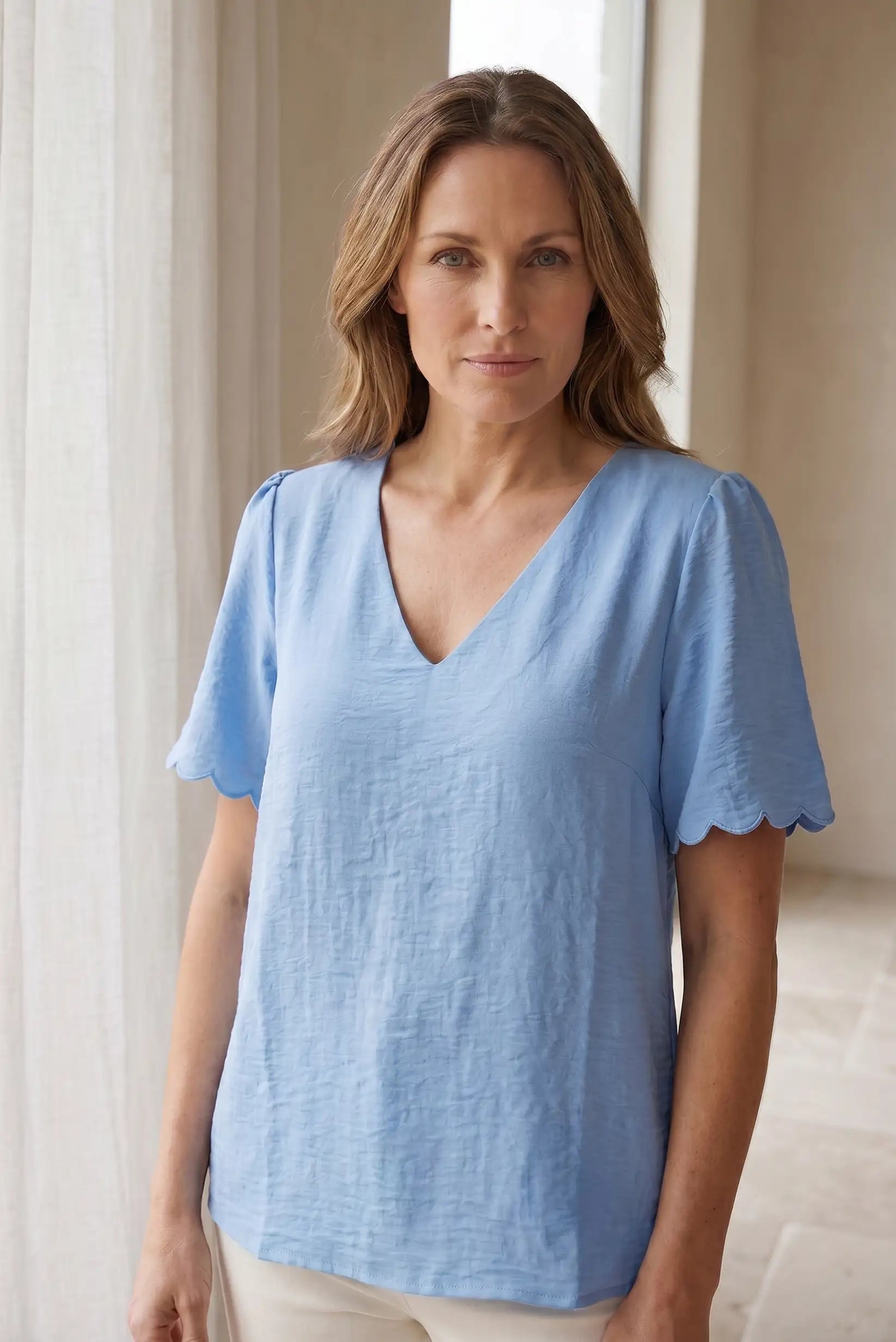 Camiseta azul mujer con cuello en V y mangas cortas onduladas, estilo casual y cómodo