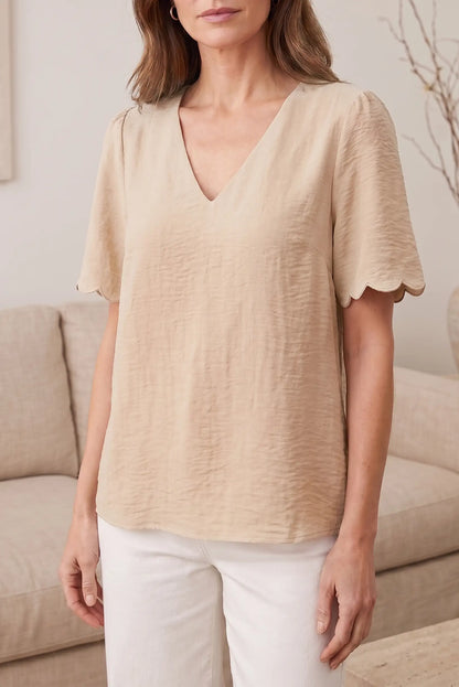 Blusa beige con cuello en V y mangas cortas con detalle de volante, ideal para looks casuales y estilosos.