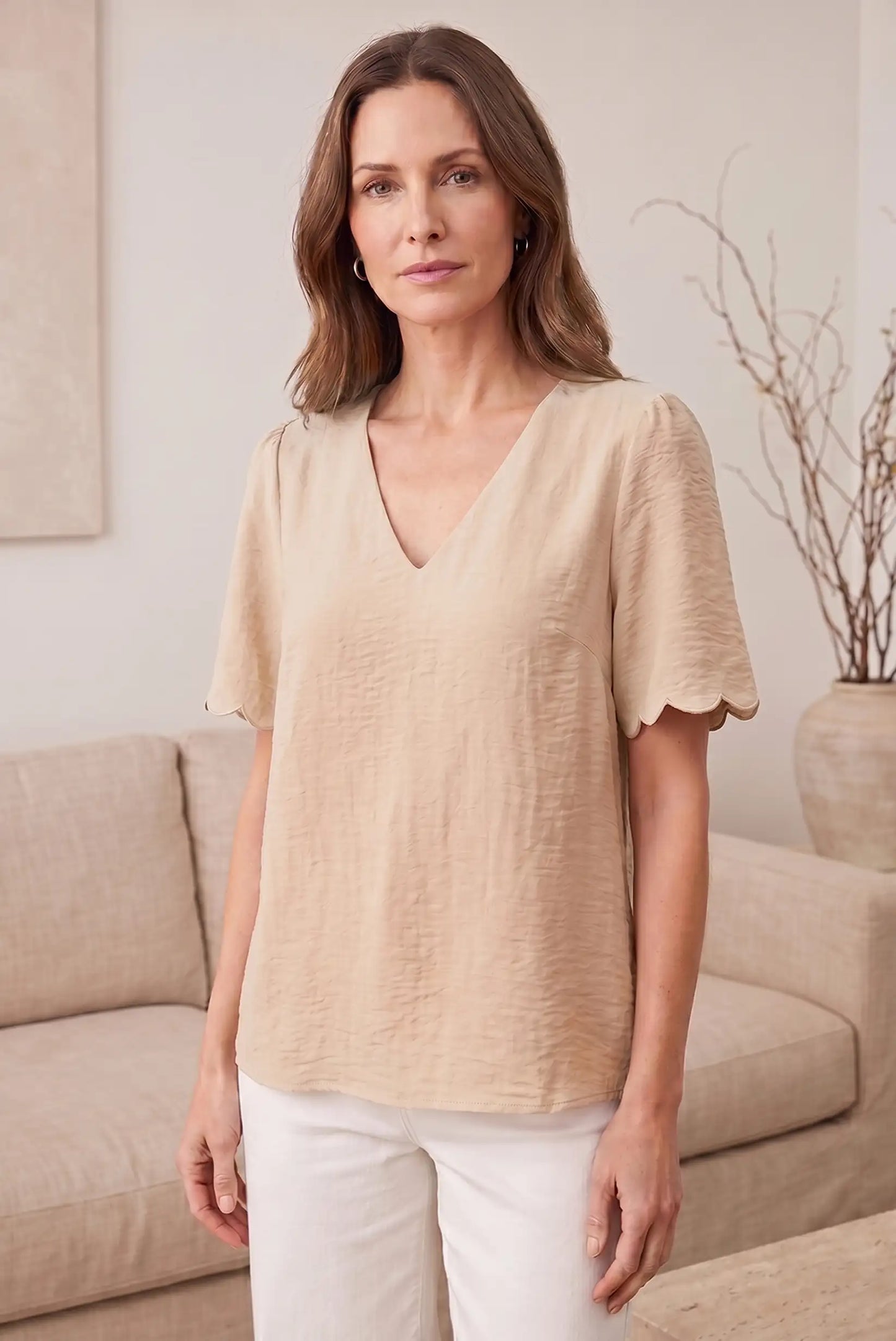 Blusa beige con cuello en V y mangas cortas con volantes, ideal para looks casuales y estilosos
