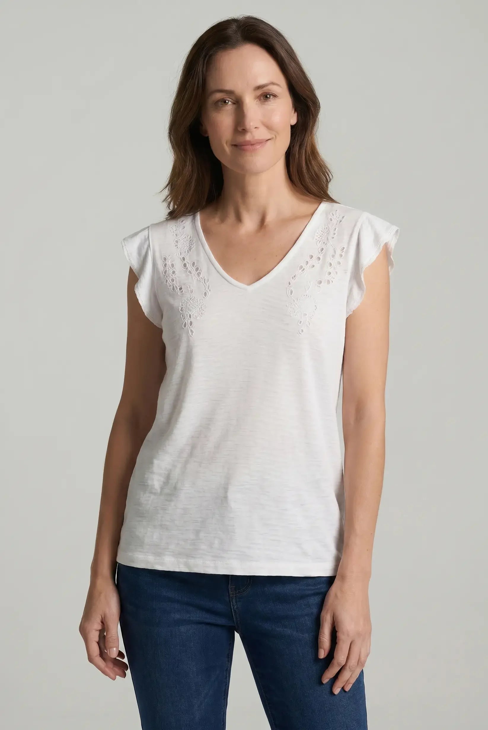 Mujer con camiseta blanca calada de manga corta y cuello en V, look casual de primavera