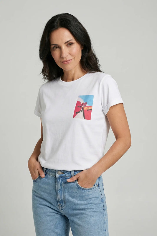 Mujer con camiseta blanca de manga corta con estampado colorido y jeans claros