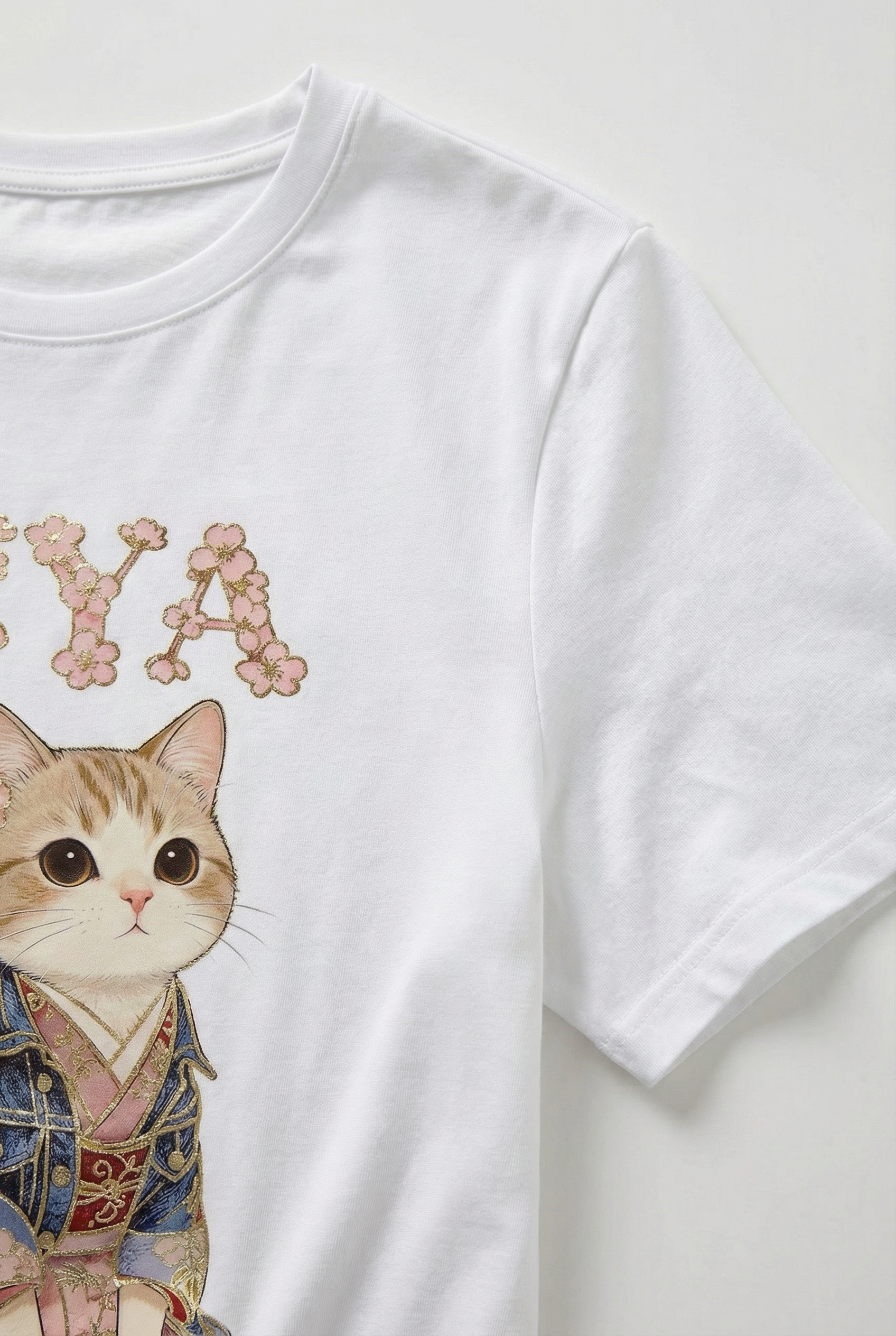 Camiseta blanca de mujer manga corta con ilustración de gato y letras decorativas rosas.