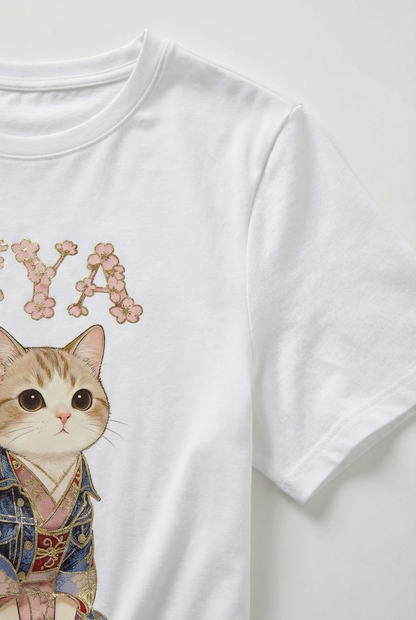 Camiseta blanca de mujer manga corta con ilustración de gato y letras decorativas rosas.