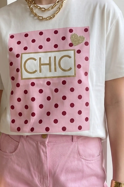 Camiseta blanca de mujer con estampado rosa de lunares y la palabra CHIC, combinada con pantalones rosas.