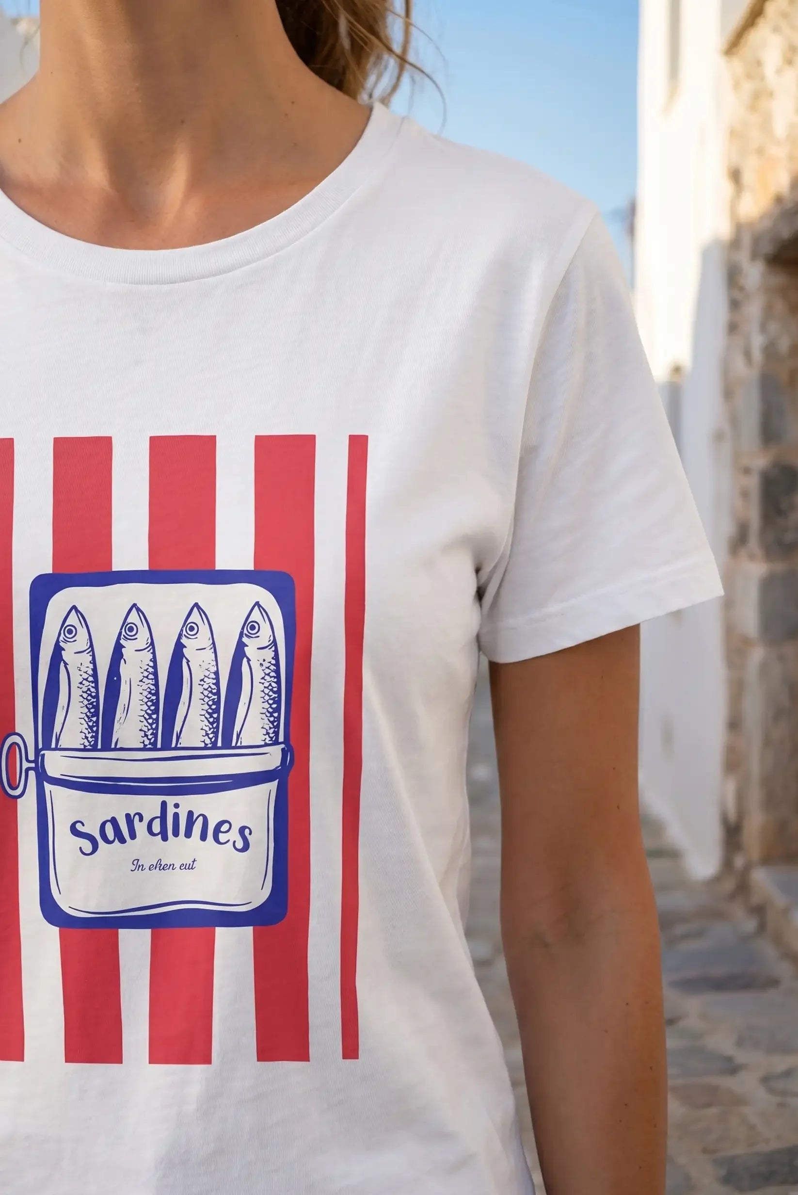 Camiseta blanca con estampado de sardinas y rayas rojas, ideal para looks casuales y estilosos.