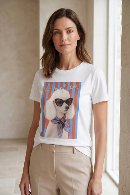 Mujer con camiseta blanca de manga corta, estampado de caniche con gafas y pañuelo, rayas coloridas