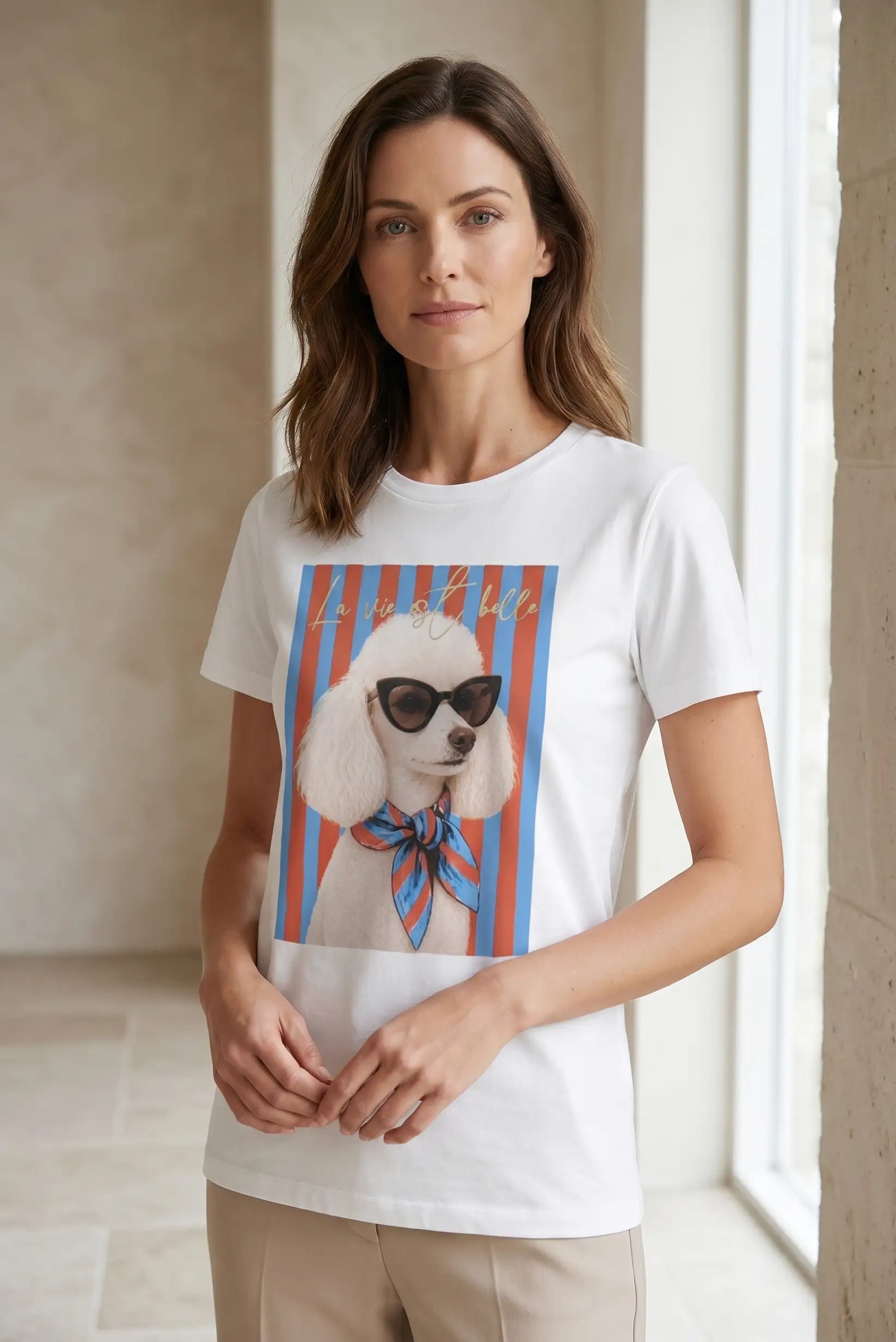 Mujer con camiseta blanca de manga corta estampada con caniche, rayas rojas y azules.