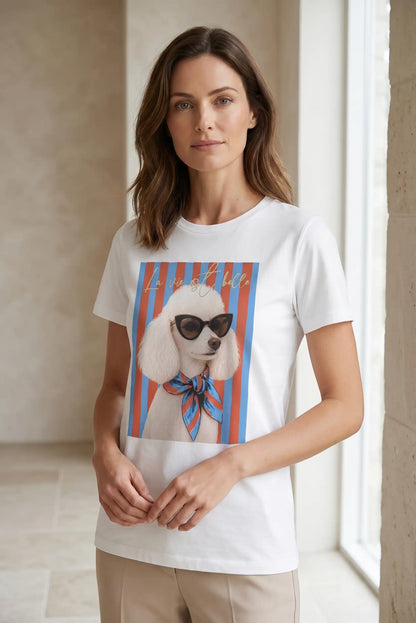 Mujer con camiseta blanca de manga corta estampada con caniche, rayas rojas y azules.