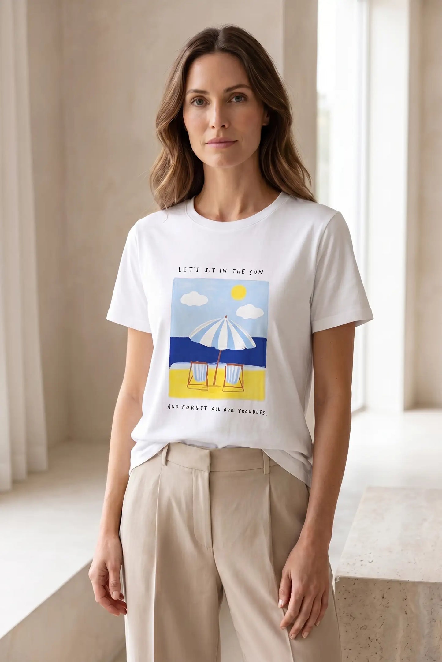 Mujer con camiseta blanca de manga corta con estampado de playa, look casual femenino