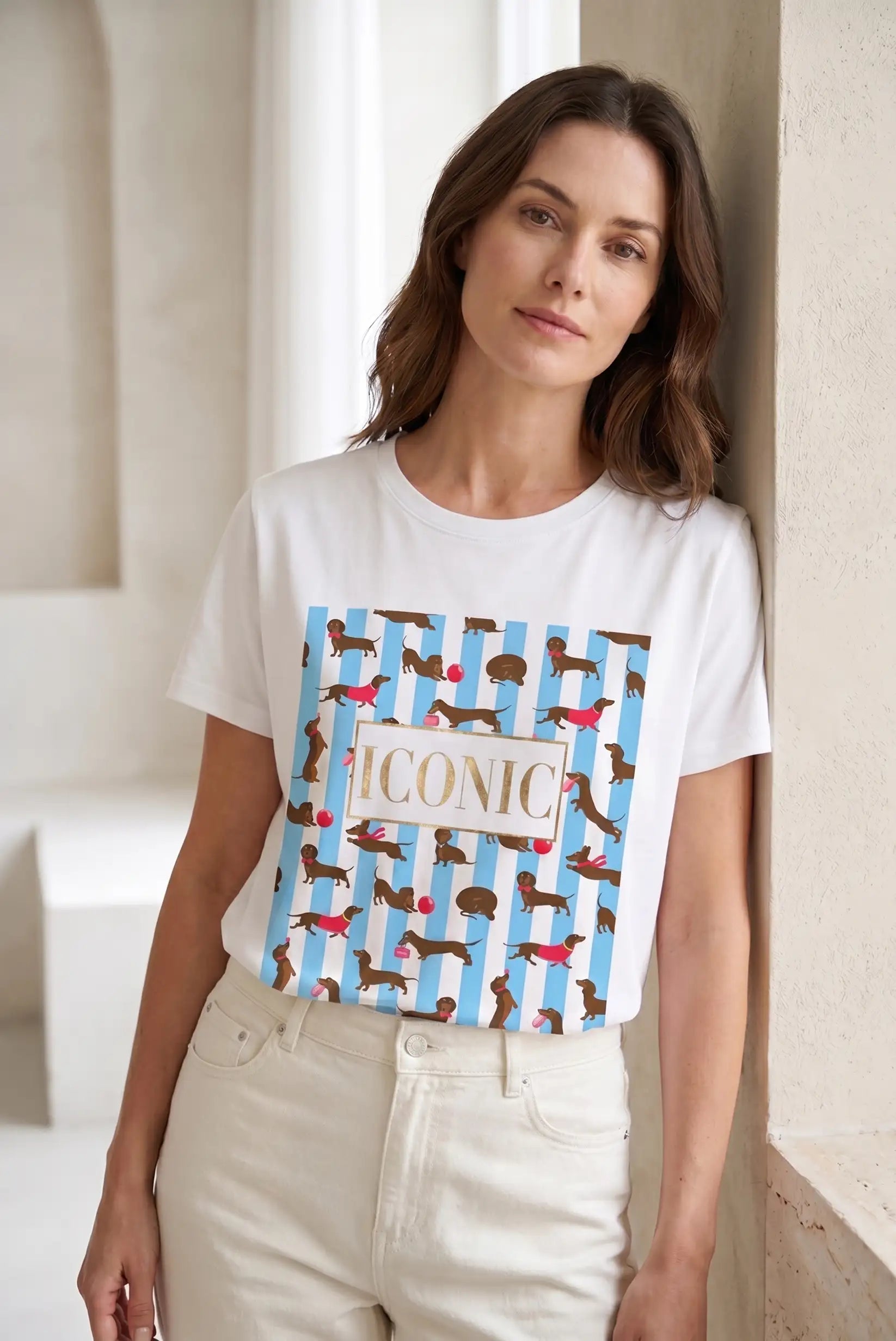 Mujer con camiseta blanca de manga corta, estampada con rayas azules y perros salchicha.