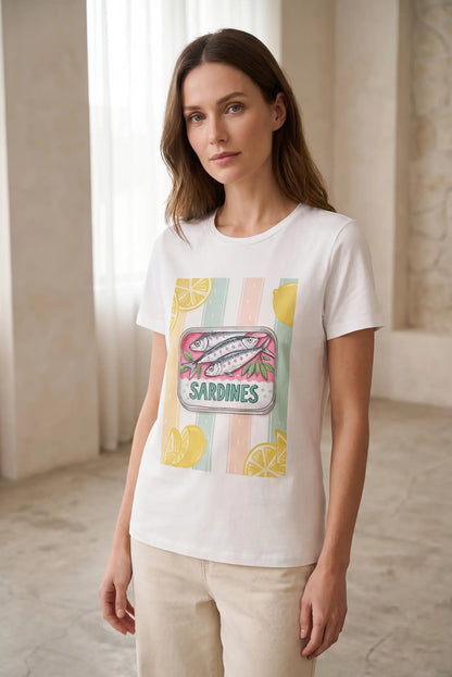 Mujer con camiseta blanca de manga corta, estampado de latas de sardinas y limones, moda casual.