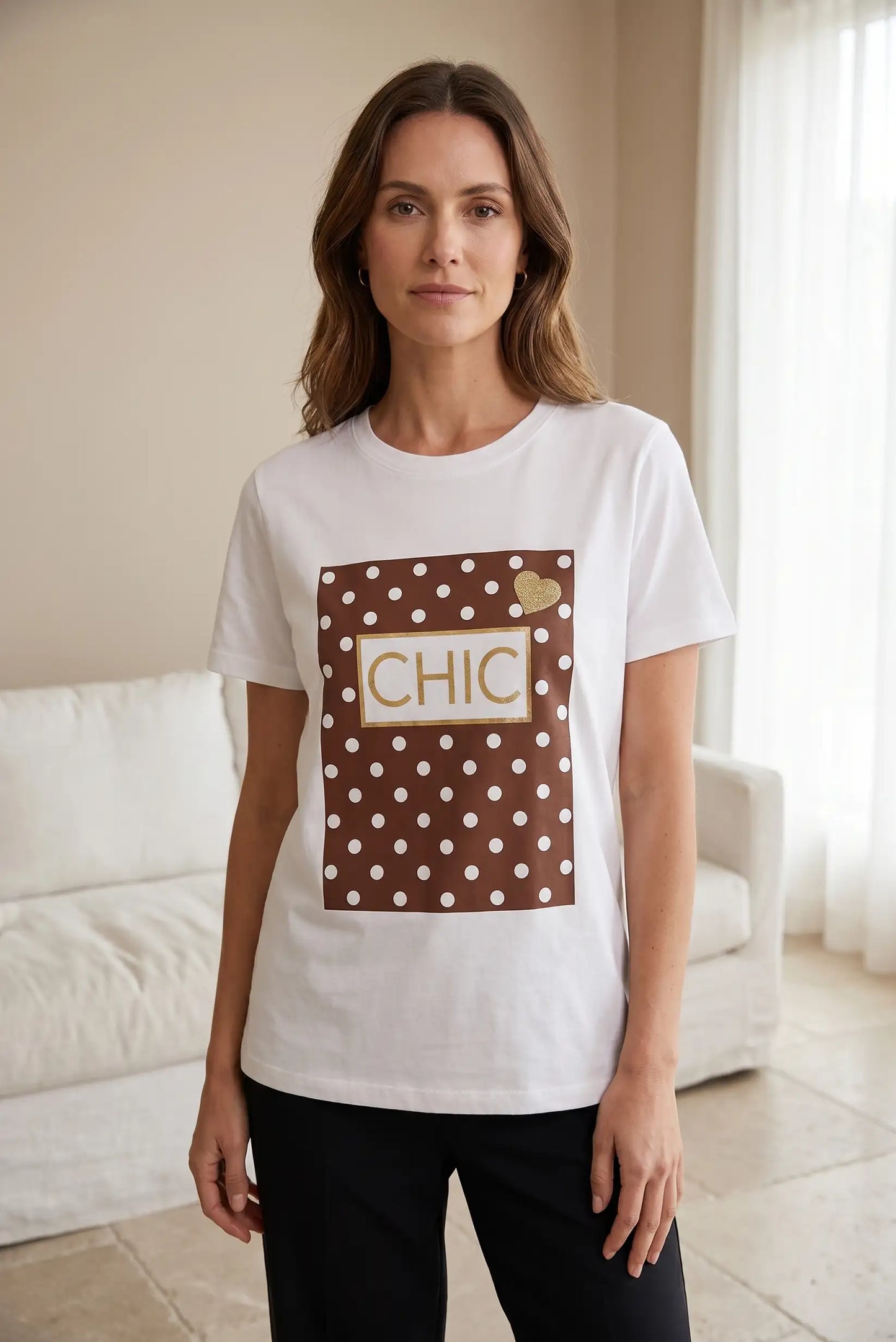 Mujer con camiseta blanca de manga corta, estampado marrón de lunares y palabra CHIC
