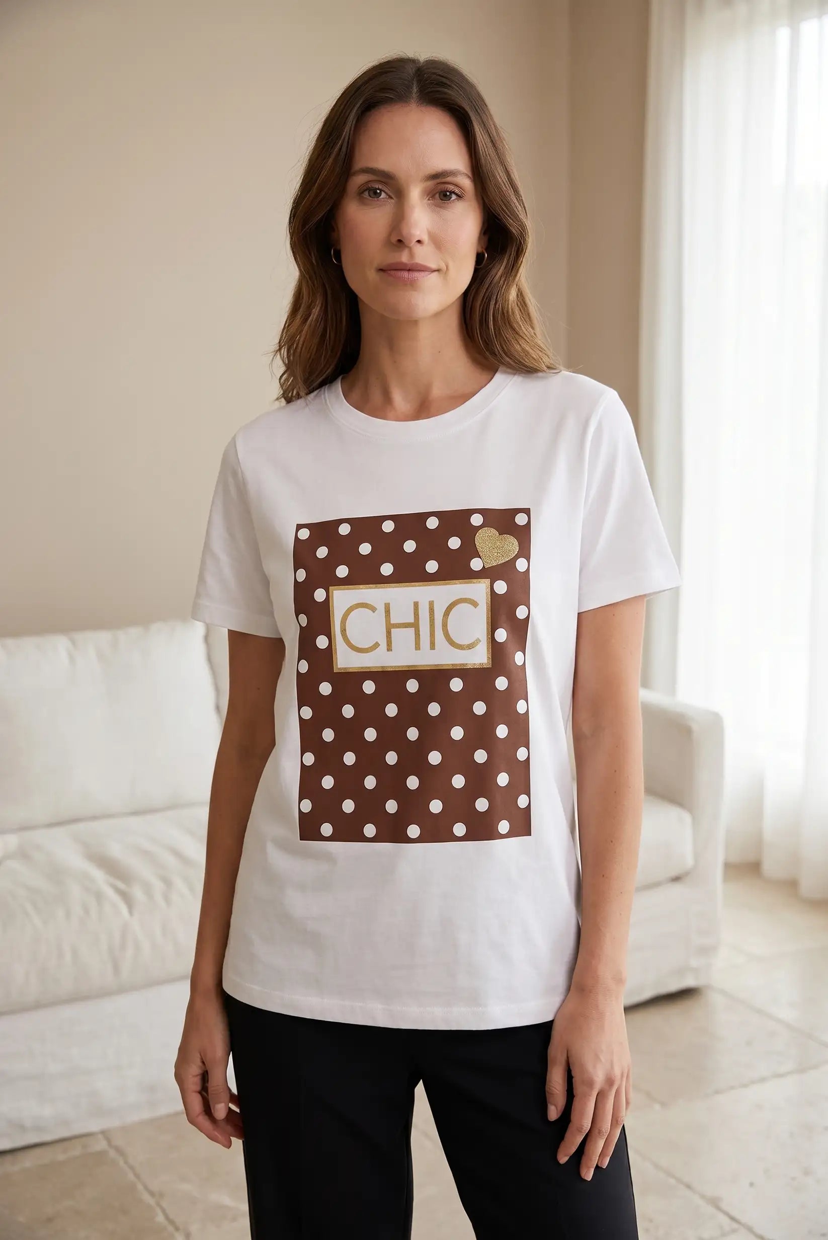 Mujer con camiseta blanca de manga corta, estampado marrón de lunares y palabra CHIC