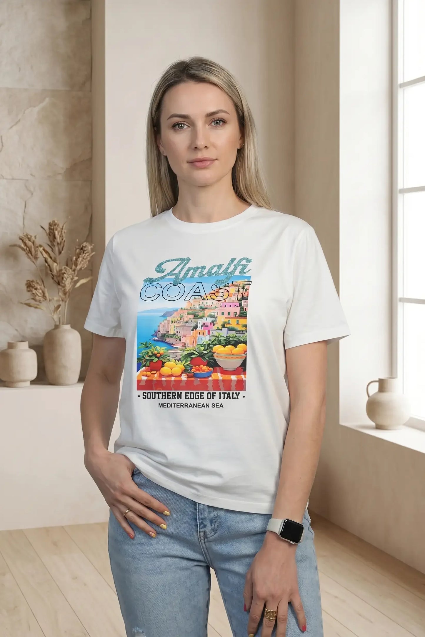 Mujer con camiseta blanca de manga corta con estampado colorido de Amalfi Coast y jeans celestes