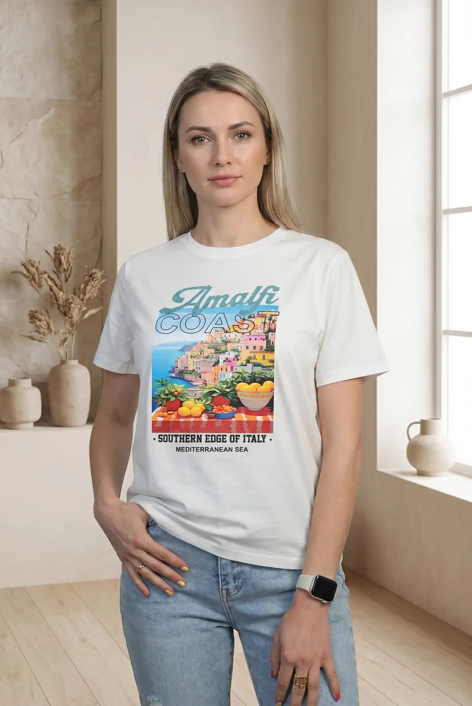Mujer con camiseta blanca de manga corta con estampado colorido de Amalfi Coast y jeans celestes