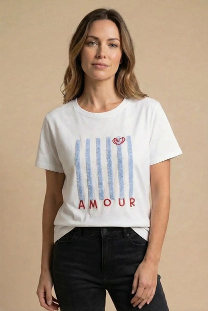 Mujer con camiseta blanca estampada con rayas azules y texto Amour, moda casual