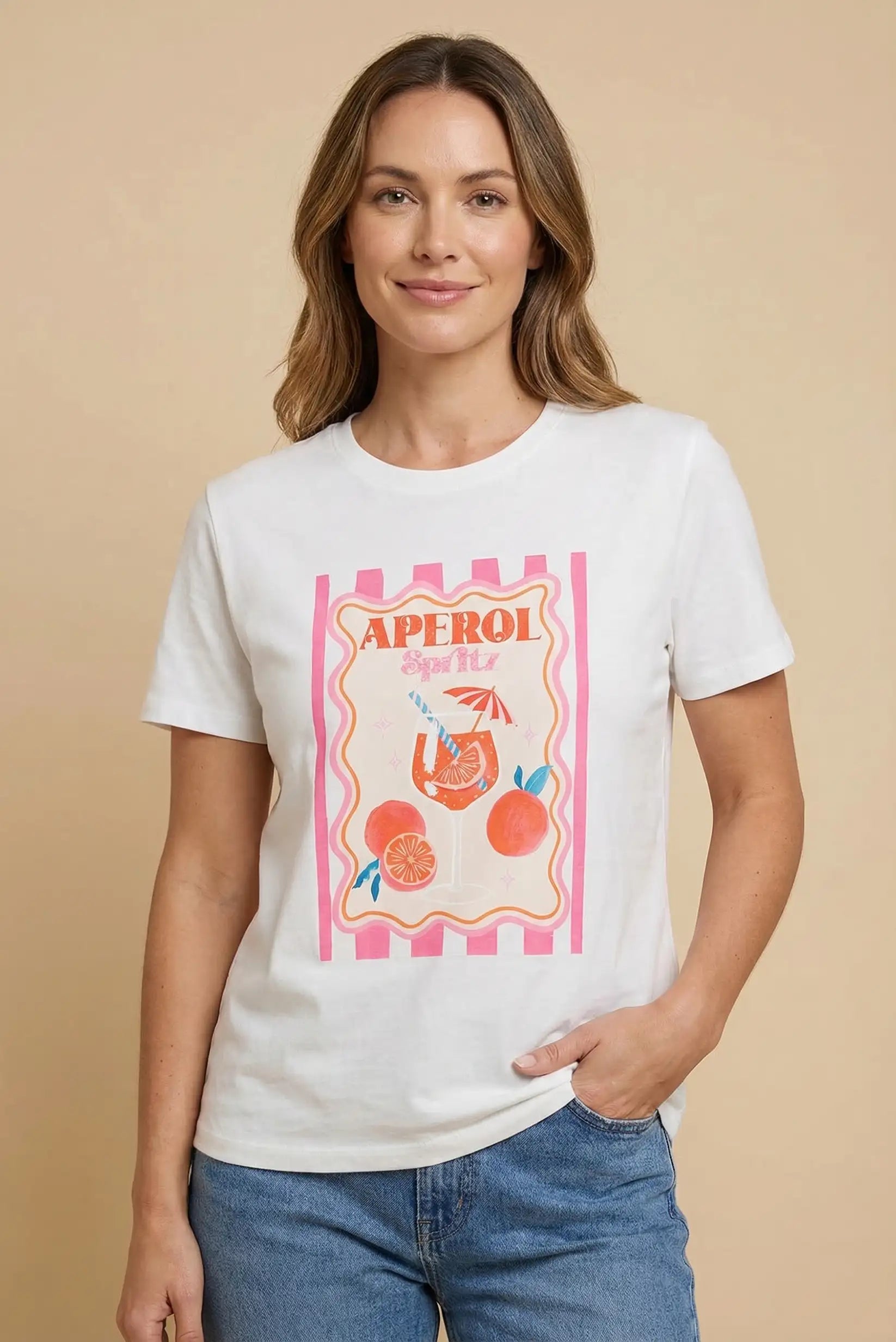 Mujer con camiseta blanca estampada de cóctel Aperol Spritz y jeans, moda casual femenina.