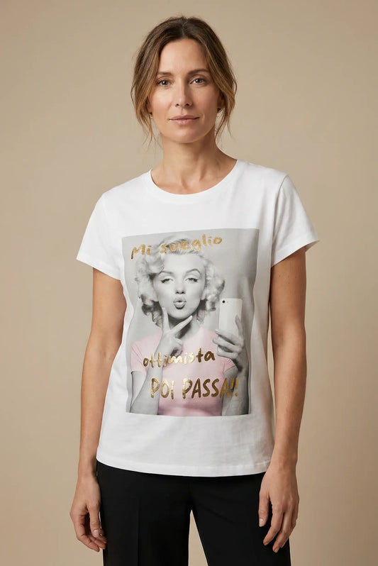 Mujer con camiseta blanca estampada, imagen vintage y mensaje dorado, moda casual femenina.