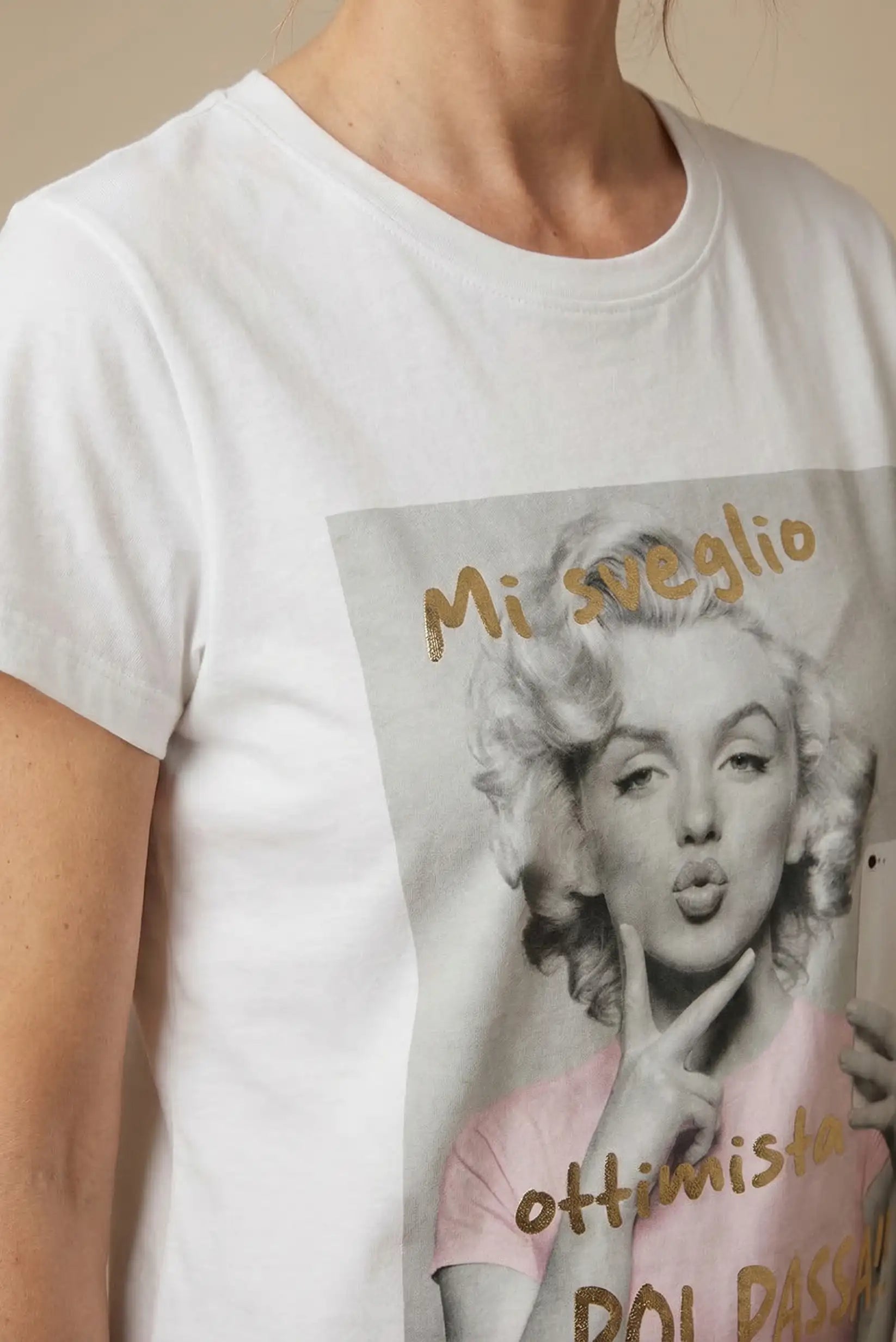 Camiseta blanca de mujer con estampado gráfico y frase en dorado, look casual primaveral.