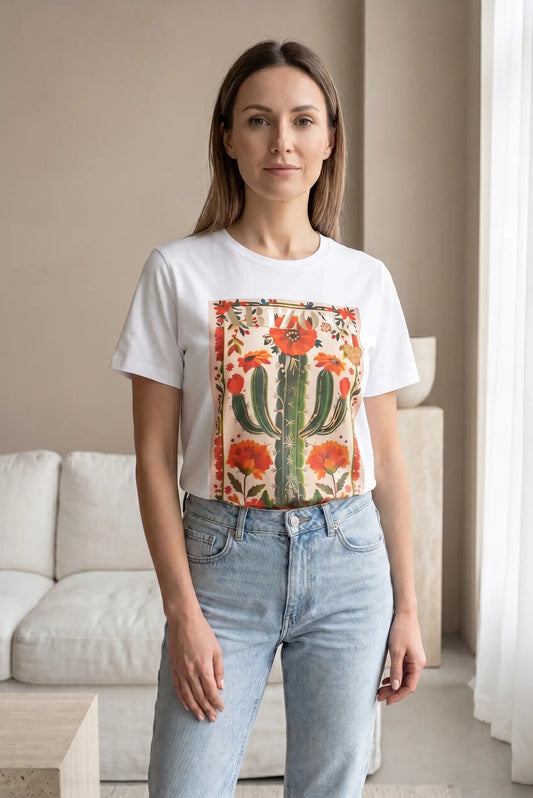 Mujer con camiseta blanca de manga corta, estampado de cactus y flores, y jeans claros