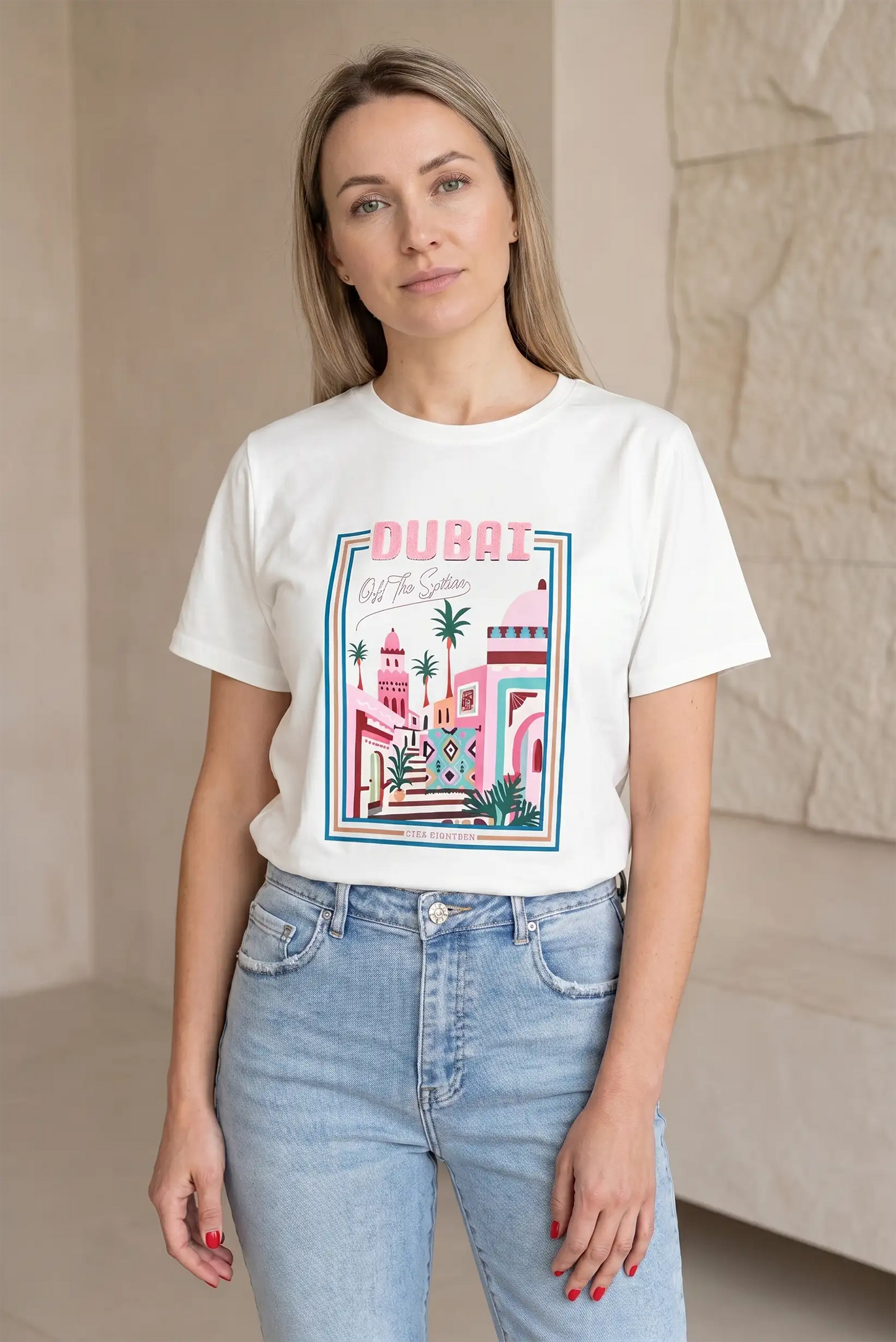 Mujer con camiseta blanca de manga corta con estampado colorido de Dubái y jeans claros