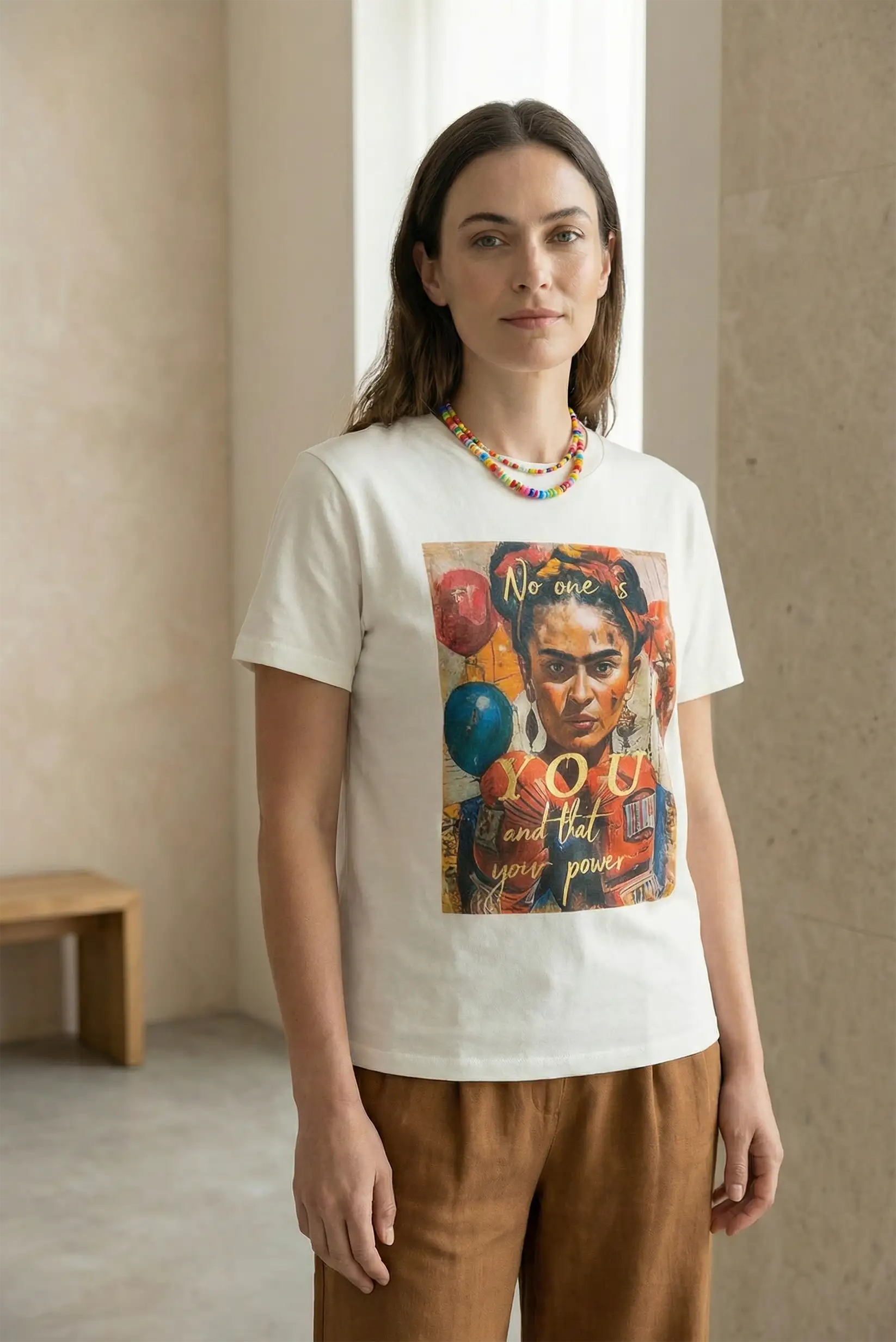 Mujer con camiseta blanca de manga corta con ilustración colorida de Frida Kahlo, estilo casual