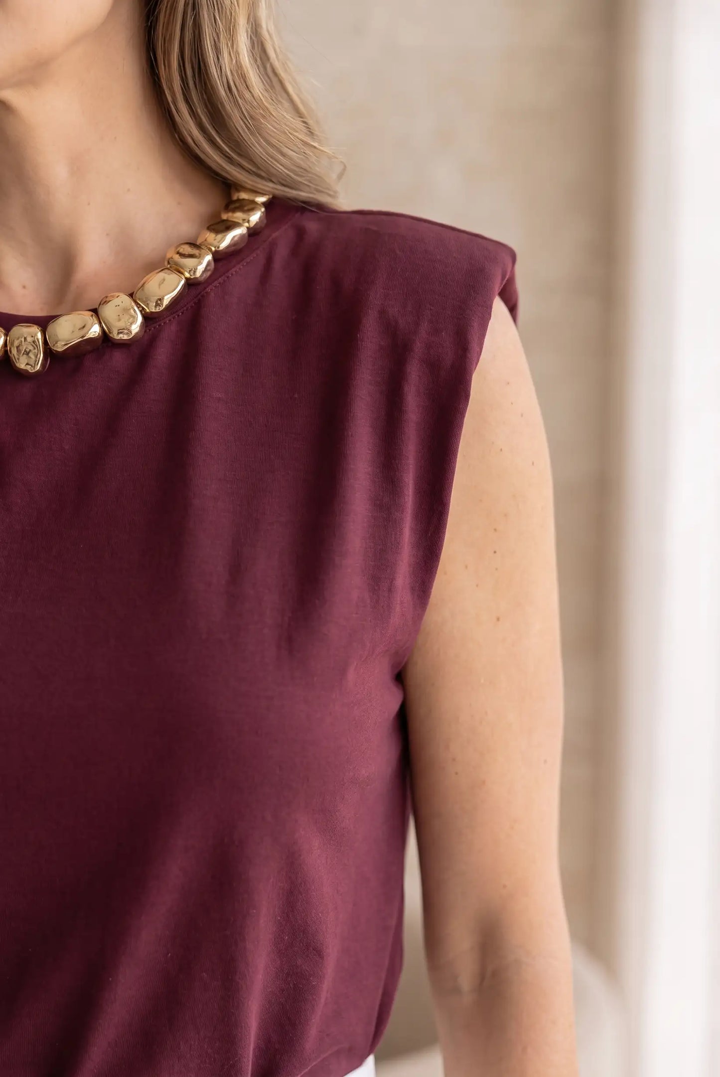 Camiseta sin mangas color vino con collar dorado, moda femenina elegante y cómoda