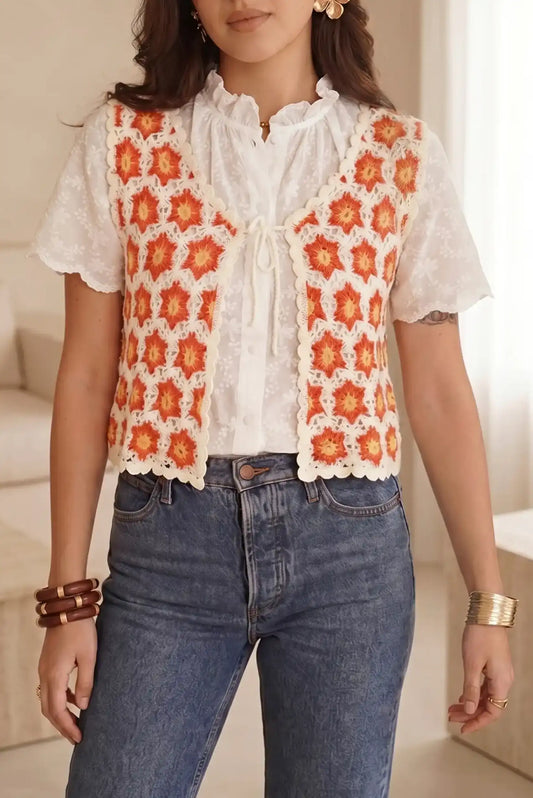 Chaleco tejido con flores naranjas sobre blusa blanca y jeans, moda femenina casual y estilosa
