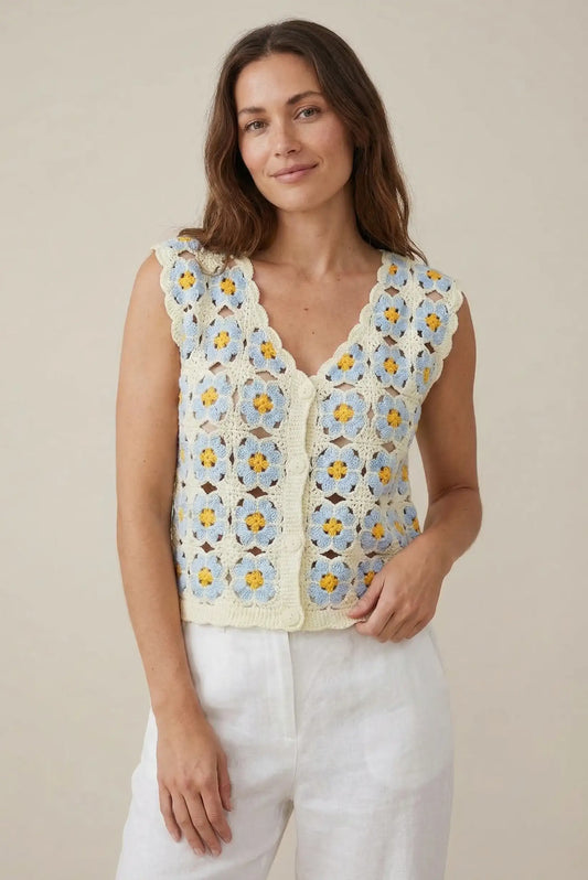 Mujer con chaleco de crochet azul y beige con flores, look primaveral casual