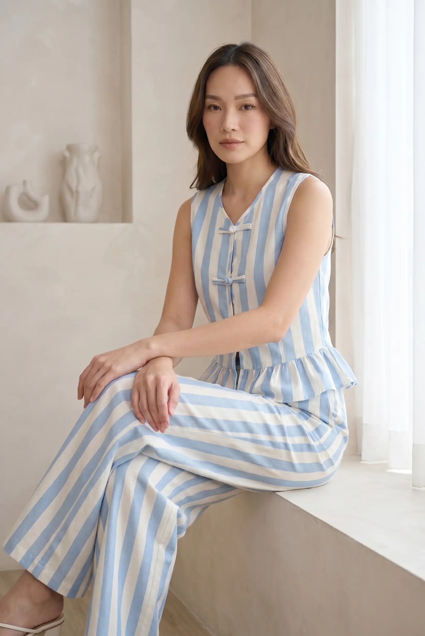 Mujer con chaleco y pantalón de rayas azul y blanco, look casual y elegante