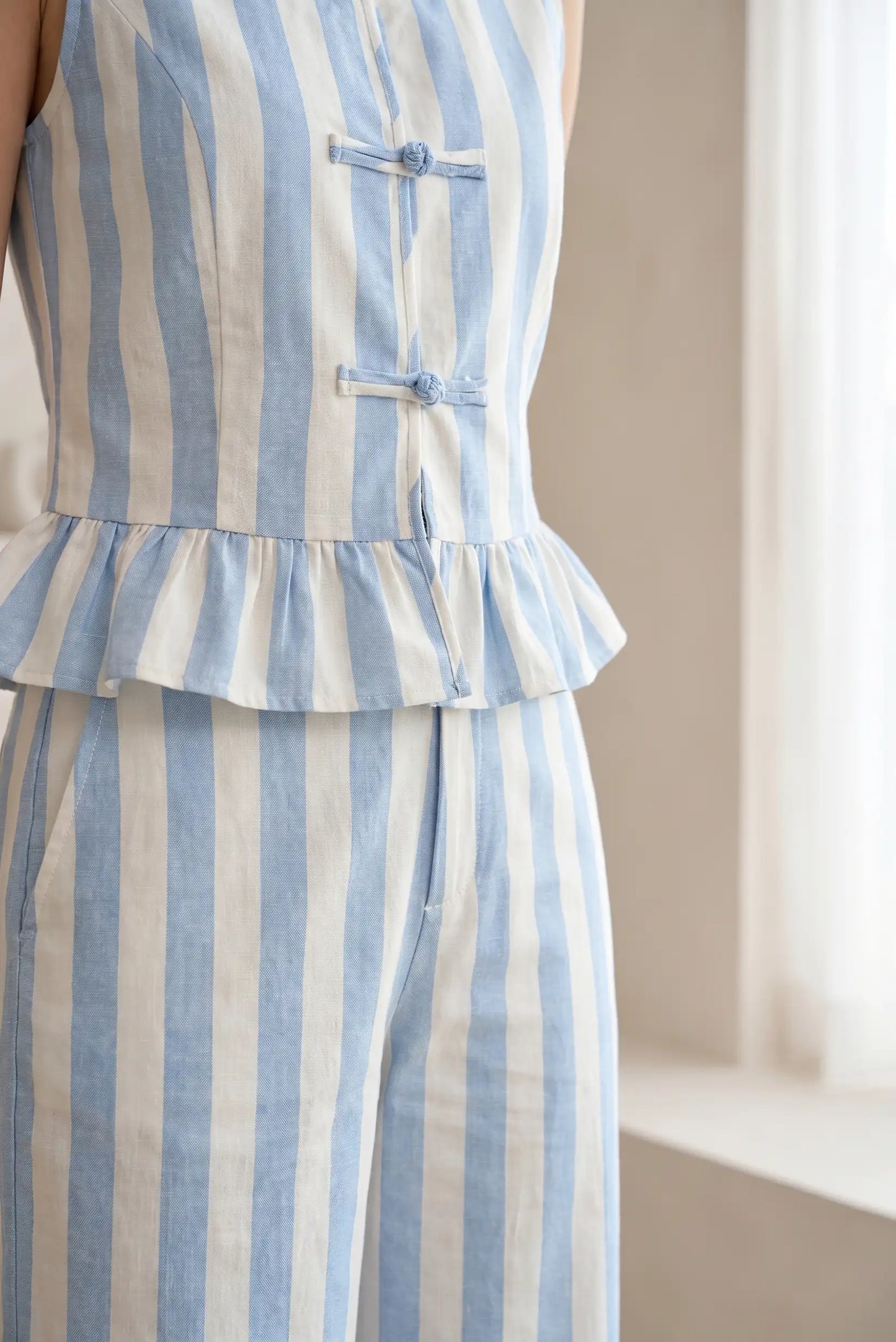 Chaleco de mujer sin mangas y pantalón de rayas azul y blanco, estilo casual.